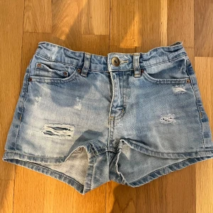 Lågmidjade jeanssjorts - Snygga lågmidjade jeansshorts, köpa second hand men är från lager 157. Ingen storlek står inuti, men midjemåttet tvärs över är ca 33cm och längden på shortsen är ca 23cm. Jättefint skick!🌸