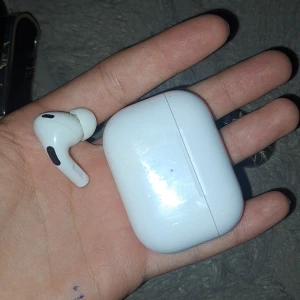 vita AirPods Pro - Säljer ett snyggt svart AirPods-fodral från iDeal of Sweden med marmormönster i guldiga toner. Fodralet är hårt och skyddar dina hörlurar, perfekt för dig som vill ha en stilren look. Passar AirPods Pro och ger en lyxig känsla till dina tech-prylar.