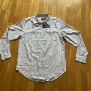Randig Polo Ralph Lauren skjorta - Vit skjorta med blå ränder från polo Ralph lauren, den är i nyskick och bara testad.Storlek m och true to size. Fundera inte på att skriva vid fundering!