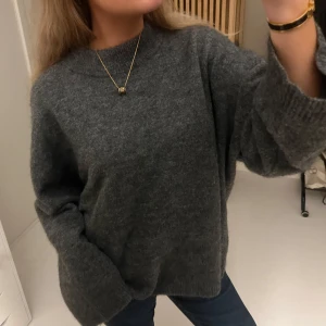 Mörkgrå oversized stickad tröja - Mysig och oversized stickad tröja i mörkgrått. Tröjan har en rund halsringning, långa ärmar och breda muddar. Perfekt för lager-på-lager och chill dagar. Passar dig som gillar en avslappnad och trendig stil. Använd ett fåtal gånger!❤️