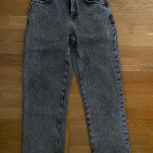 Grå jeans från Grunt, modell Harmon - Säljer ett par snygga grå jeans från Grunt, modell Harmon Ash Grey. Jeansen har en klassisk femficksdesign, raka ben och normal passform. Materialet är bomull med en cool tvättad look som ger en vintagekänsla. Perfekta till sneakers eller boots.