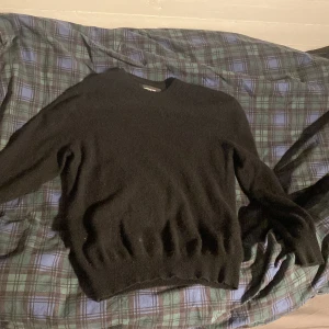 Svart kashmirtröja från Lawrence Grey - Mjuk och lyxig svart tröja från Lawrence Grey i 100% kashmir. Klassisk rund halsringning och långärmad modell med ribbade muddar. Perfekt för dig som vill ha en stilren och bekväm look med premiumkänsla. Priset är ej hugget i sten.