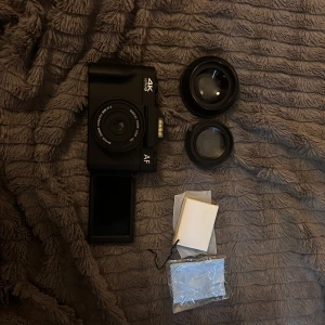 Digital kamera  - Bilderna visar en digital kamera med 4K Ultra HD, två utbytbara objektiv, rengöringsduk och tillbehör. Samt minneskort , två batterier och laddare följer med. Kameran har en vridbar skärm och levereras i originalförpackning. Perfekt för dig som vill ta snygga bilder och skapa content till sociala medier. Snygg och modern design.