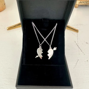 Arrow heart halsband  - Två matchande silver halsband med delade hjärthängen – perfekta att dela med en vän eller partner. Halsbanden är 100 % rost- och nickelfria. Kedjorna är 40 cm långa men kan förlängas med ytterligare 5 cm. Hör gärna av dig om du har några frågor ☺️