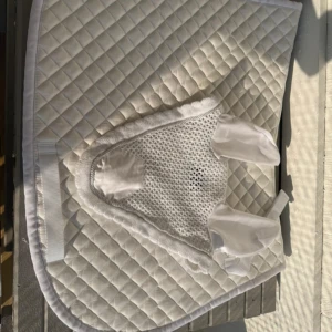 Set med schabrak och huva - Vit set med schabrak och huva. Schabraket är lite mer creme vit medans de runt om är vitt samt huvan.   Schabraket är använt en gång, men är tvättad och tagits bort nästintill allt häst hår. Huvan är helt oanvänd.   Schabraket är i full, allround och huvan 