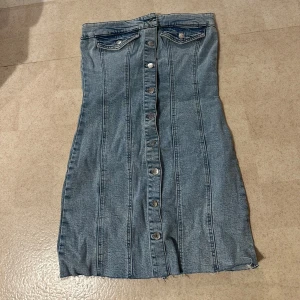 Blå jeansklänning med knappar framtill - Snygg blå jeansklänning med knappar. Köpt på ginatricot för 599kr, alltid använd och lappen är kvar. Säljer för 399kr. Storlek S