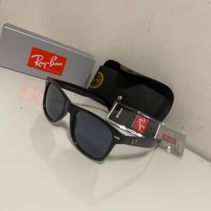 Svarta Ray-Ban Wayfarer solglasögon - Svarta Ray-Ban Wayfarer solglasögon med mörka glas och ikonisk fyrkantig form. Kommer med originalfodral och Ray-ban box. Har haft dem i några månader men vill sälja dem nu. Måste nåtera att dem är lite repiga men inget som syns. Pris kan diskuteras  
