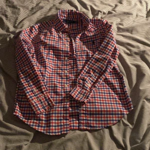 Rutig skjorta från Ralph Lauren M - Riktigt snygg rutig skjorta från Ralph Lauren i rött, blått och vitt. Klassisk button-down med lång ärm, knappar framtill och broderad logga på bröstet. Skjortan är i bomull och har en skön passform som funkar till många stilar.Storlek M men sitter som S.