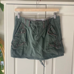 Grön kjol med fickor från Only - Militärgrön kortkjol från Only med flera fickor och knappar framtill och baktill. 