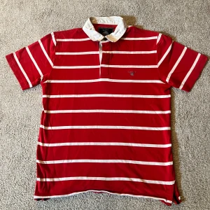 Rödvit randig pikétröja från GANT - Snygg röd pikétröja från GANT i storlek M