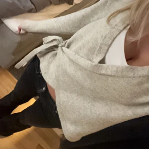 Beige omlottkofta med knyt - Supermysig beige omlottkofta med knyt i sidan. Koftan har lång ärm och är i ett mjukt stickat material💕