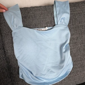 Ljusblå linnetopp från NA-KD - Supersöt ljusblå linnetopp från NA-KD med breda axelband. Aldrig använd. Säljer då den är för liten för mig.