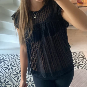 Svart topp  - Säljer denna jättefina topp från Nelly då den inte kommer till anvöndning, skriv för mer bilder!