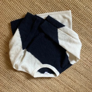 Marinblå/vit stickad tröja från Gina tricot - Säljer en stickad tröja från Gina tricot i marinblått och vitt med ett snyggt mönster. Tröjan har rund hals och långa ärmar. Är andvänd en del men är i bra skick.