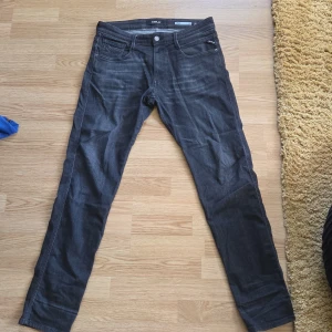 Svarta Replay jeans, midja 32/32 - Snygga svarta jeans från Replay med klassisk femficksdesign och diskret Replay-logga på bakfickan. Jeansen har raka ben och normal passform, tillverkade i mjukt denimtyg som sitter skönt hela dagen.