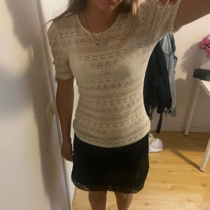 Beige spetsblus från Vila - Supersöt beige spetsblus från Vila med korta puffärmar och rund halsringning. Blusen har ett detaljerat spetsmönster över hela och sitter figurnära. Perfekt att styla med kjol eller jeans för en trendig look.