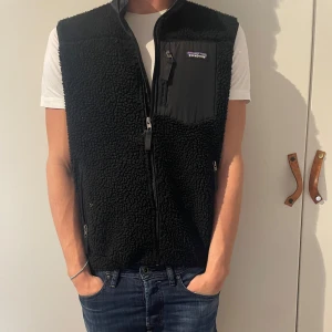Patangonia väst - Säljer en fet Svart fleeceväst från Patagonia. Den är i storleken M. Modellen är 185 och väger ca 77kg. Perfekt nu till hösten, skriv vid minsta funderingar!