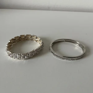 Två glittriga silverfärgade armband - Säljer två snygga armband i silverfärg.