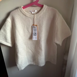 Vit stickad kortärmad tröja från gina Young  - Säljer en mjuk och mysig stickad tröja från gina Young i varm vit färg. Tröjan har korta ärmar, rundad halsringning. Säljer då den är förliten och det var försent att lämna tillbaka paketet🩷🩷 läs gärna bio💘 OBS! Skriv innan köp, säljer på fler ställen!