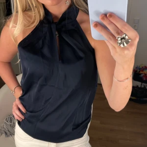 Festtopp - Riktgt snygg festtopp i marinblå, oanvänd och passar XS och S. Helt ny utan deffekter!!