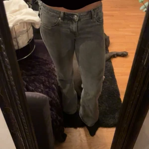 Grå bootcut jeans med låg midja - Säljer ett par grå jeans med snygg bootcut och låg midja. Jeansen har klassisk femficksdesign och är i ett mjukt denimtyg som sitter skönt. Perfekta för dig som gillar en avslappnad men trendig look.