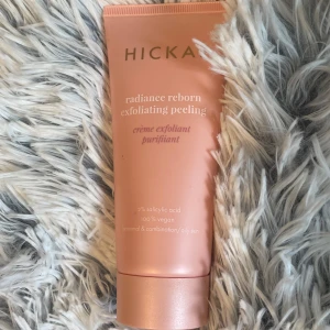 Hickap Radiance Reborn Exfoliating Peeling - Ej testad. Fräsch exfolierande peeling från Hickap i en snygg rosa tub. Innehåller 2% salicylsyra och är 100% vegansk, perfekt för normal, kombinerad eller oljig hud. Tuben är stilren med guldiga detaljer och rymmer 100 ml krämig produkt.