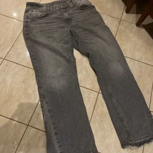 Zara flared jeans grå - Säljer ett par grå jeans från Zara i rak modell med snygga råa kanter nertill. Jeansen har klassisk femficksdesign och är tillverkade i jeansmaterial. Perfekta för dig som gillar en avslappnad och trendig look.