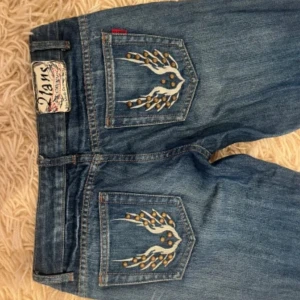 Blå jeans med nitar från CX-Croop - Snygga blå jeans från CX-Croop med coola nitar och broderier på fickorna både fram och bak. Jeansen har bootcut-modell och klassisk femficksdesign. Materialet är jeans i bomull och de har låg midja för en avslappnad vibe. Ny pris 800.