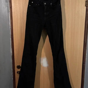 Svarta bootcut jeans från Perfect Jeans - Svarta jeans från Perfect Jeans i klassisk bootcut-modell med hög midja. Jeansen har fem fickor, knapp och dragkedja framtill samt raka ben som blir vidare nedtill. Perfekta för dig som gillar en tidlös och snygg look.