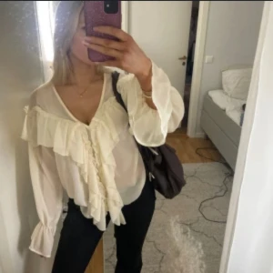 Vit volangblus med v-ringning - Säljer en superfin festlig blus! Passar perfekt till ett par svarta jeans eller kostymbyxor till exempel! Första bilden är lånad💕