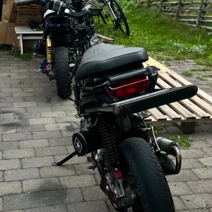 Wheelie bar till Yamaha slider  - Bilderna visar en moped och dess ramdelar, men ingen bok syns på bilderna. Därför kan ingen bokbeskrivning eller taxonomi ges.