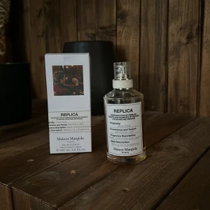Maison Margiela Replica Jazz Club 100ml - Maison Margiela Replica Jazz Club är en Eau de Toilette med en stilren, transparent glasflaska och vit etikett. Doften har inslag av rom, cocktails och cigarrer, inspirerad av Brooklyn 2013. Flaskan rymmer 100 ml och kommer i en vit kartong med bild och text. Den är perfekt ny till kallare väder, hör av dig vid funderingar ✌️✌️