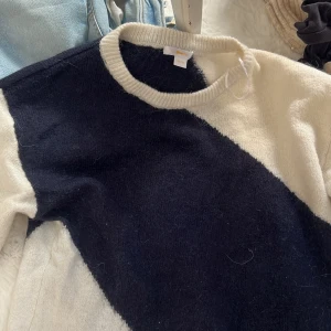 Svartvit stickad tröja Gina Tricot - Snygg stickad tröja från Gina Tricot i marinblå och vitt med coolt diagonalblockat mönster. Tröjan har rund halsringning och långa ärmar. säljer då den inte kommer till användning. 