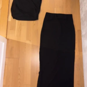 Svart långkjol från SHEIN - Säljer en svart långkjol från SHEIN i storlek 36. Kjolen har en enkel och stilren design med rak passform och resår i midjan. Materialet är mjukt och stretchigt, vilket gör den bekväm att bära. Perfekt att matcha med en crop top för en snygg look.