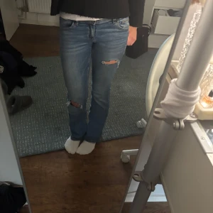 Bootcut jeans - Säljer ett par blå jeans med bootcut och dom är lågmidjade. Förra ägaren hade gjort hål i dom och så att dom ser lite slita ut. Pris kan diskuteras💕