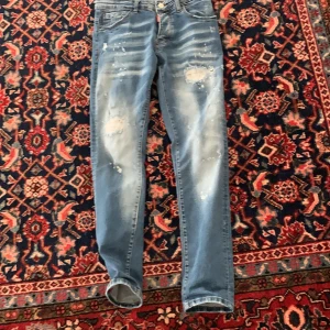 Blå slim fit jeans med rivningar  - Säljer ett par ljusblå slim fit  jeans med slitningar och distressed detaljer på benen.  normal midja och är tillverkade i stretchigt denim för en tight passform. Perfekta för dig som gillar en trendig och avslappnad look.