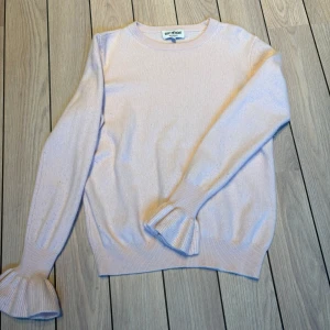 Ljusrosa kashmirtröja Soft Goat S - Supersöt ljusrosa tröja i 100% kashmir från Soft Goat. Tröjan har rund halsringning, långa ärmar och snygga volangdetaljer vid ärmsluten. Lite noppror under ärmen som blir på kashmirtröjor, men lätt tas bort med kan eller noppborttagare.