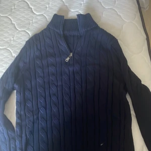 Marinblå stickad half zip från ByCastello - Säljer en marinblå stickad tröja från ByCastello med kabelstickat mönster. den köptes för 799kr på rea, prövad en gång