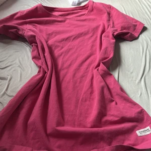 Rosa t-shirt från 157 Denim Makers - Enkel och snygg rosa t-shirtk från 157 Denim Makers. T-shirten har rund halsringning, korta ärmar och är gjord i mjuk bomull. Perfekt för en chill och avslappnad look. Liten etikett nertill med logga.