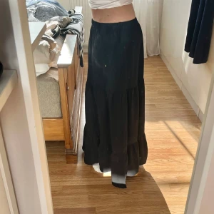 Svart långkjol - Säljer denna svarta lågmidjade långkjolen som går hela vägen ner till golvet. Jag är 166cm lång💞💞💞