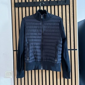 Moncler Cardigan - Mörk blå cardigan, har ett hål i armhålan som kan sys innan leverans. Skriv privat angående denna cardiganen. Storlek XS/S