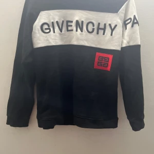 Givenchy Paris svart och vit sweatshirt - Svart och vit sweatshirt från Givenchy Paris med stor logga framtill och röd broderad patch. Priset kan diskuteras 