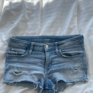 Ljusblåa jeansshorts ⛱️☀️ - Snygga ljusblåa jeansshorts från &Denim med låg midja och slitna detaljer framtill. Perfekt till sommaren!!💘💘 (de kan vara lite för små i storleken)