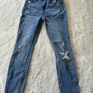 Blå ripped jeans från Amisu - Snygga blå jeans från Amisu med slitna detaljer och hål på benen för en cool, avslappnad look.  