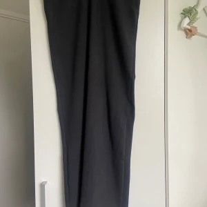 Svart långkjol - En stilren svart långkjol från Zara i storlek S. Kjolen har en rak och tajt passform med en låg midja men funkar perfekt att ha den högmidjad också. Perfekt för dig som är kortare än 170!!