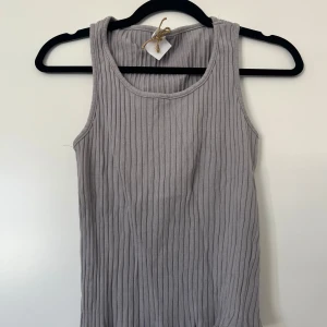 Grå ribbad linnetopp - Säljer en stilren grå ribbad linnetopp med rund halsringning. 