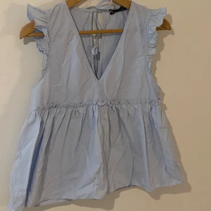 Ljusblå blus - Fin blus från Zara i jättebra skick! En minimal typ 1 mm fläck som syns på tredje bilden men i princip omöjlig att se.