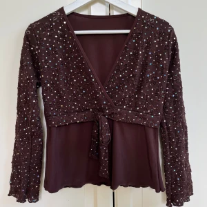 Brun sommartopp - Snygg topp med paljetter på, köpt second hand. Finns ingen lapp men uppskattar att det är storlek S-M