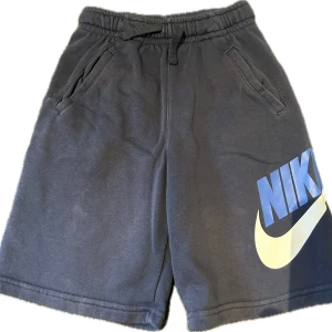 Nike shorts  - Bekväma och stilrena mjukisshorts från Nike – perfekta för träning, vardag eller bara en avslappnad dag hemma. Tillverkade i mjukt material med bra passform och klassisk Nike-logga framtill. En mångsidig favorit för både sport och chill! Fräscha och redo att användas direkt!