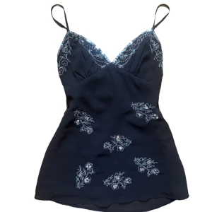 Vintage Svart blommig linnetopp med paljetter - Svart lite längre topp med paljetter. Strl XS men passar S också. 